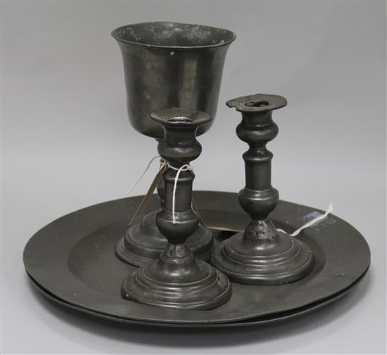 Two early 19th century pewter chargers with London touchmarks, a pewter goblet and a pair of pewter candlesticks